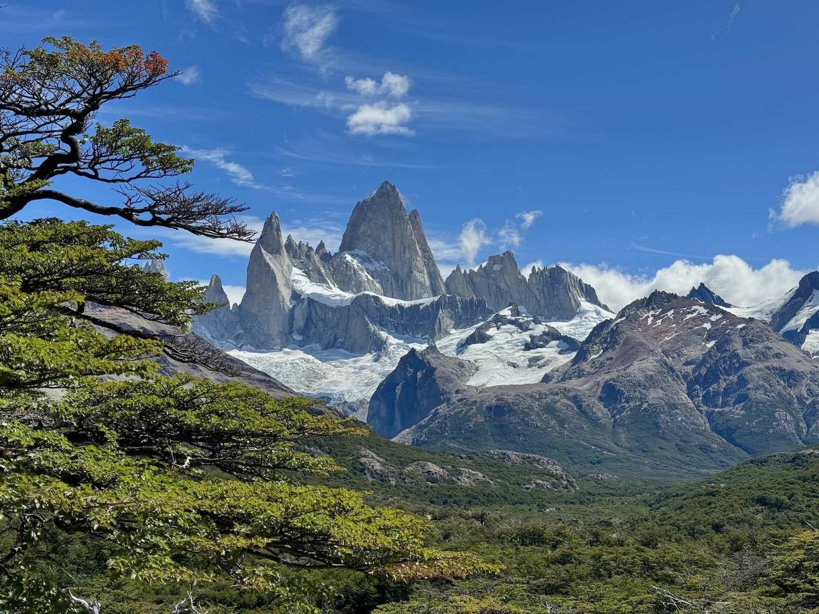 Monte Fitz Roy coberto de neve e céu azul ao fundo.