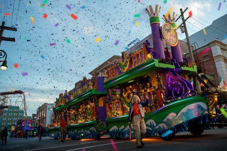 Desfile temático do Mardi Gras na Universal Studios com carros alegóricos e muita música.