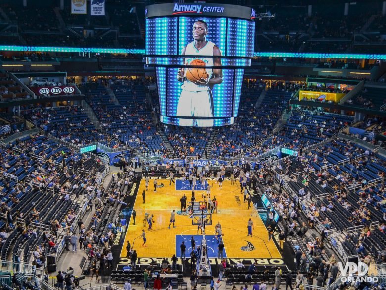 Quadra de basquete durante um jogo da NBA, com a torcida vibrando nas arquibancadas