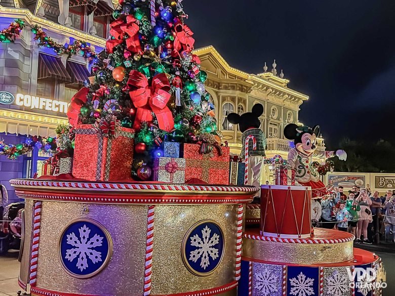 Desfile de Natal na Disney com personagens e decorações festivas.